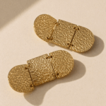 Brincos geométricos em aço dourado com três placas geométricas articuladas e textura em relevo