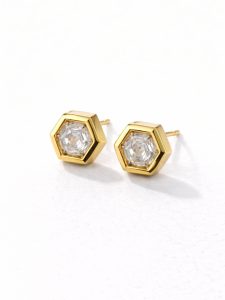 Brincos hexagonais em aço dourado com pedra central transparente e brilhante