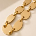 Colar em aço dourado com placas ovais lisas ligadas por pequenos elos retangulares