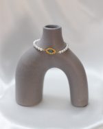 1. Pulseira de pérolas com detalhes dourados e pedra azul