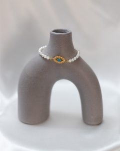 1. Pulseira de pérolas com detalhes dourados e pedra azul