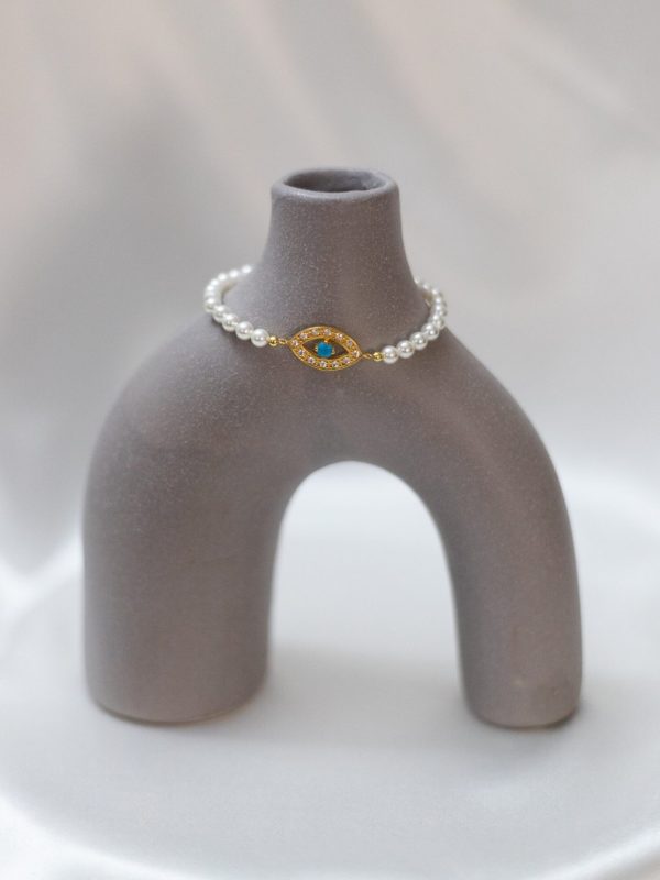 1. Pulseira de pérolas com detalhes dourados e pedra azul