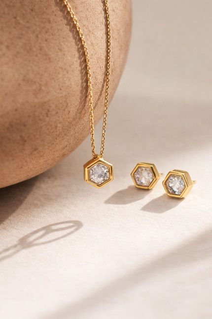 Colar hexagonal em aço dourado com pedra central brilhante e corrente delicada