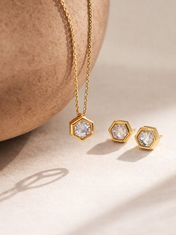 Colar hexagonal em aço dourado com pedra central brilhante e corrente delicada